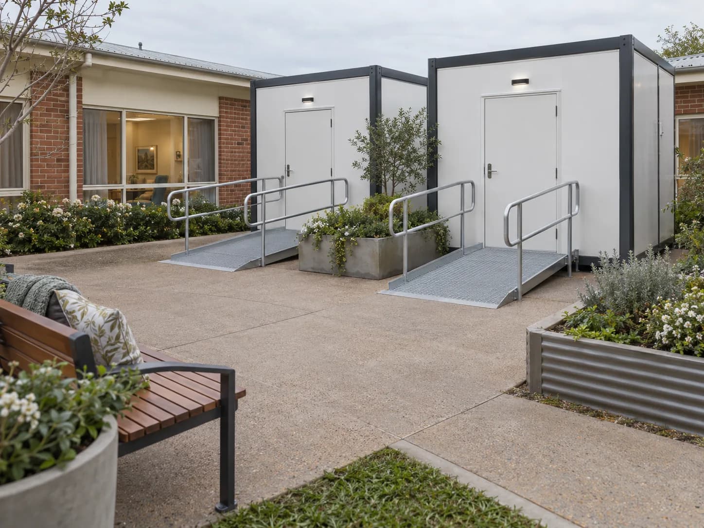 Two accessible bathroom modules with ramps in an aged care courtyard