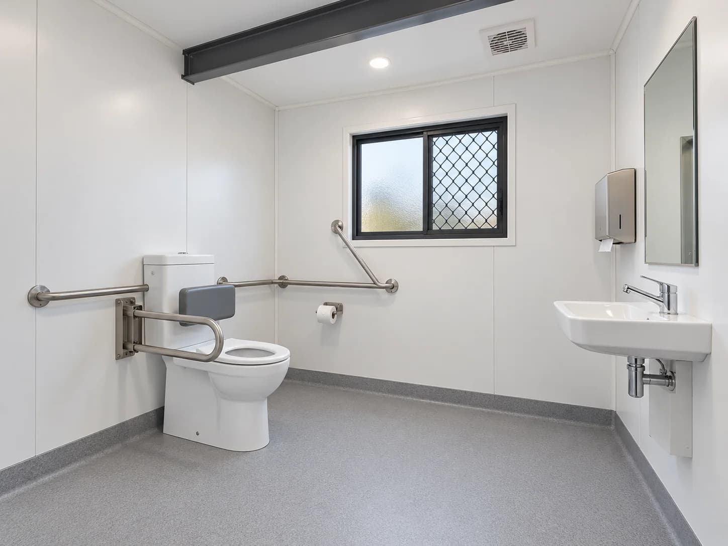 Prefab bathroom with toilet backrest, grab rails and wall-mounted basin