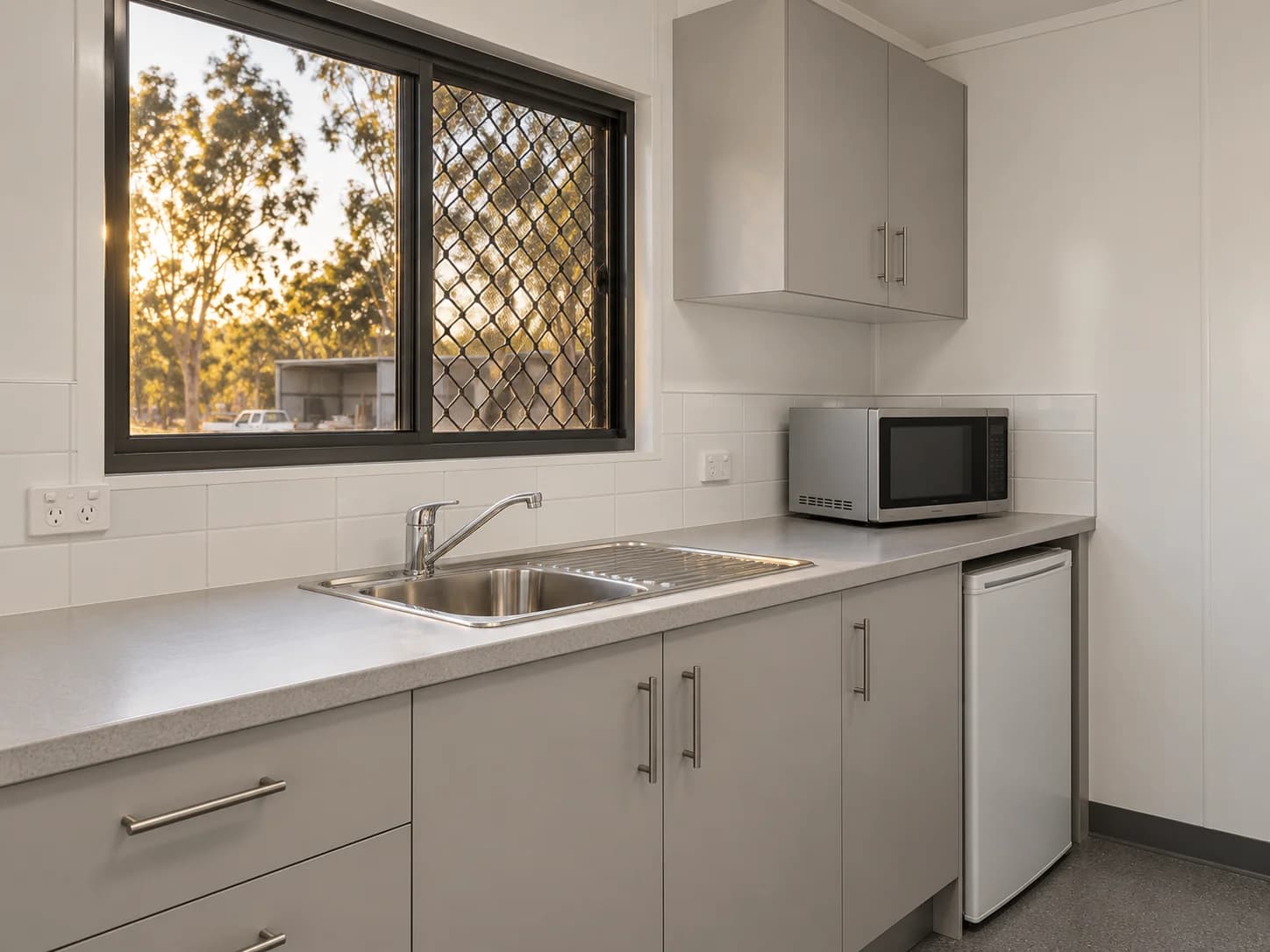 Prefab kitchenette with sink, cabinetry, microwave and underbench fridge