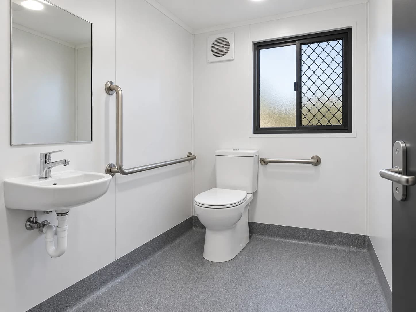 Prefab toilet room with basin, mirror and grab rails
